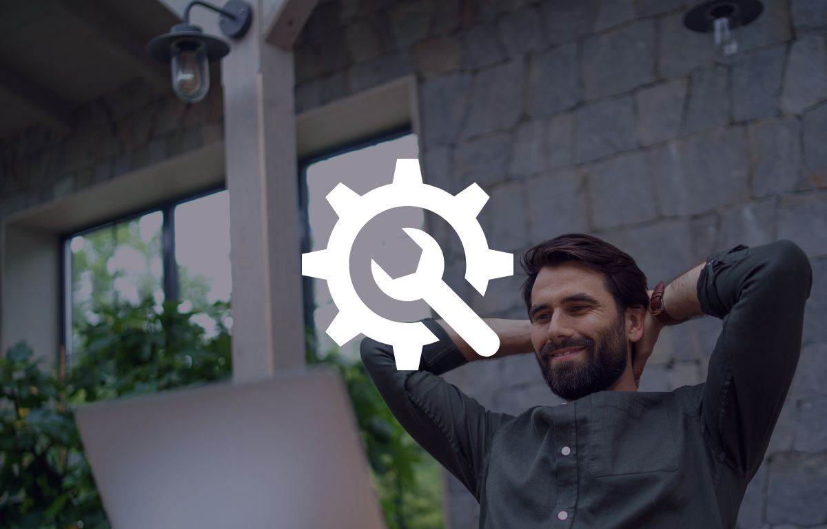 A man sits with his hands behind his head, smiling at a laptop. A white gear and wrench icon is overlaid in the center of the image. Designed by Circular Design, a not-for-profit web design agency.