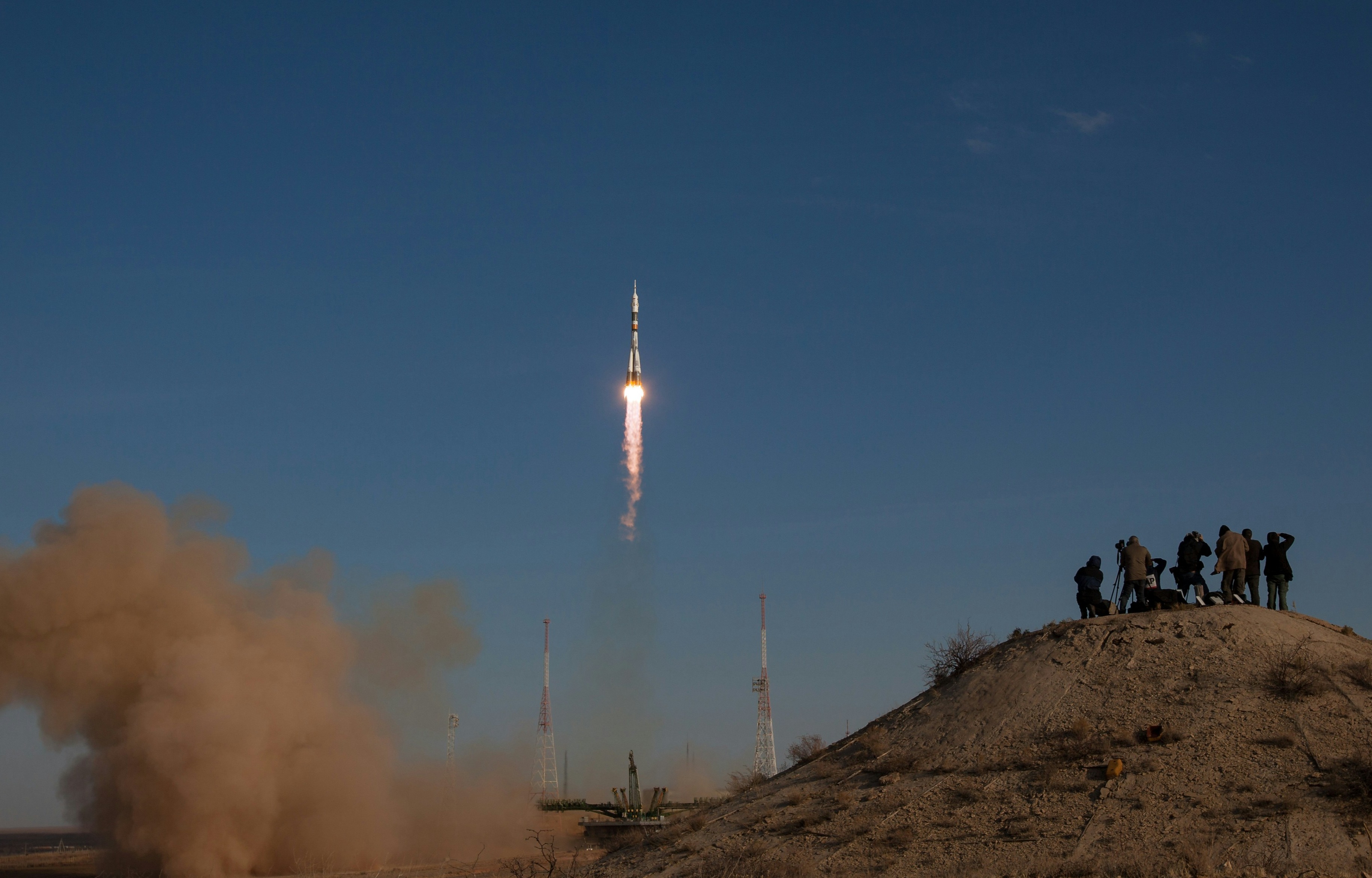 A rocket launching into the the night sky watched by a small group of people on the ground, representing a website launch campaign.